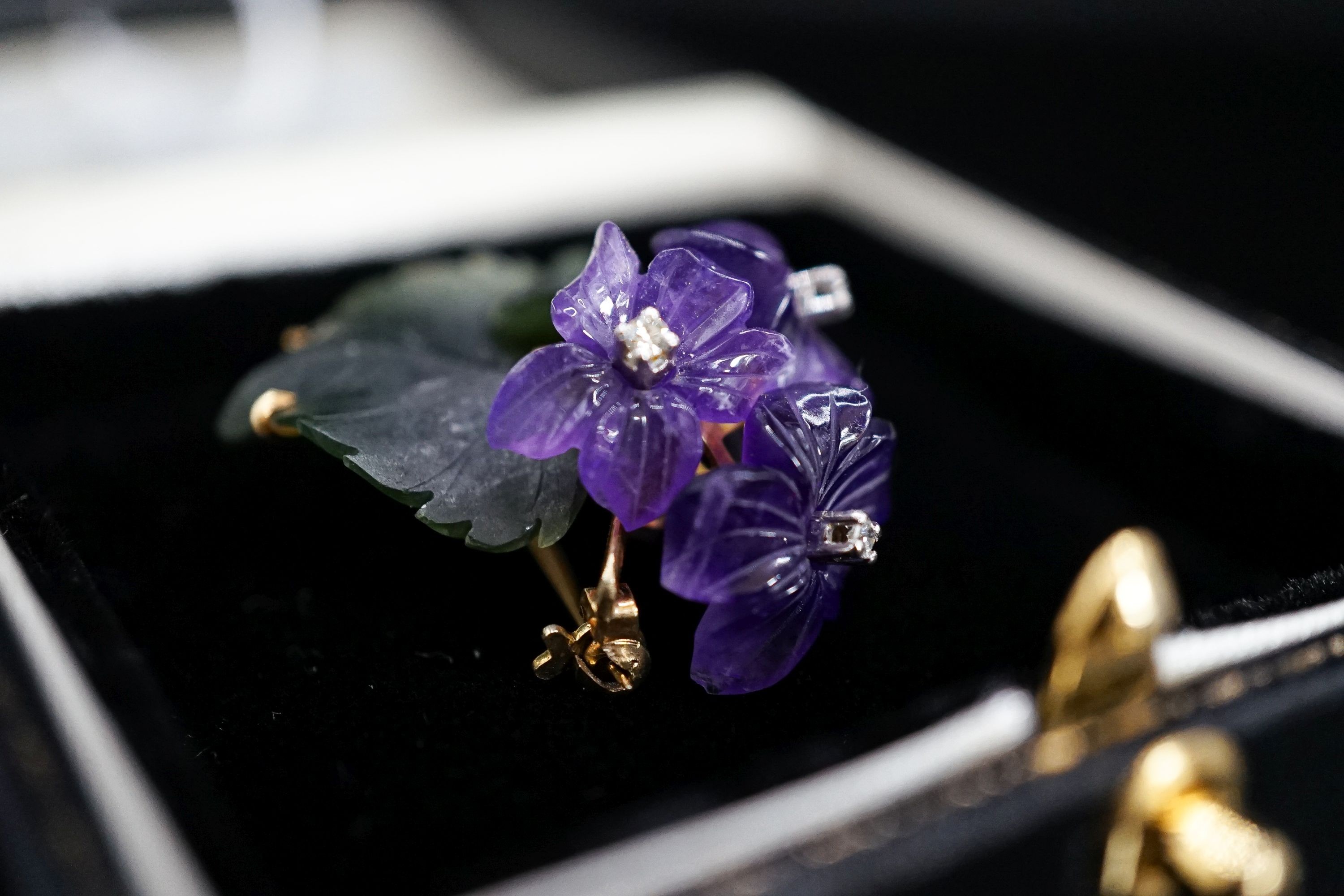 A continental Austrian? 585 yellow metal, diamond chip, carved nephrite and carved amethyst set flower head brooch, 39mm, gross 8.5 grams.